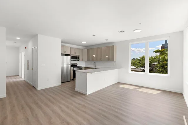 a view of kitchen with wooden floor and electronic appliances