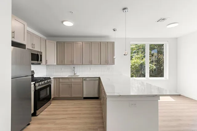 a kitchen with stainless steel appliances granite countertop a stove a sink and a refrigerator
