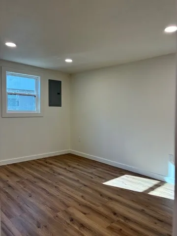 a view of empty room with wooden floor