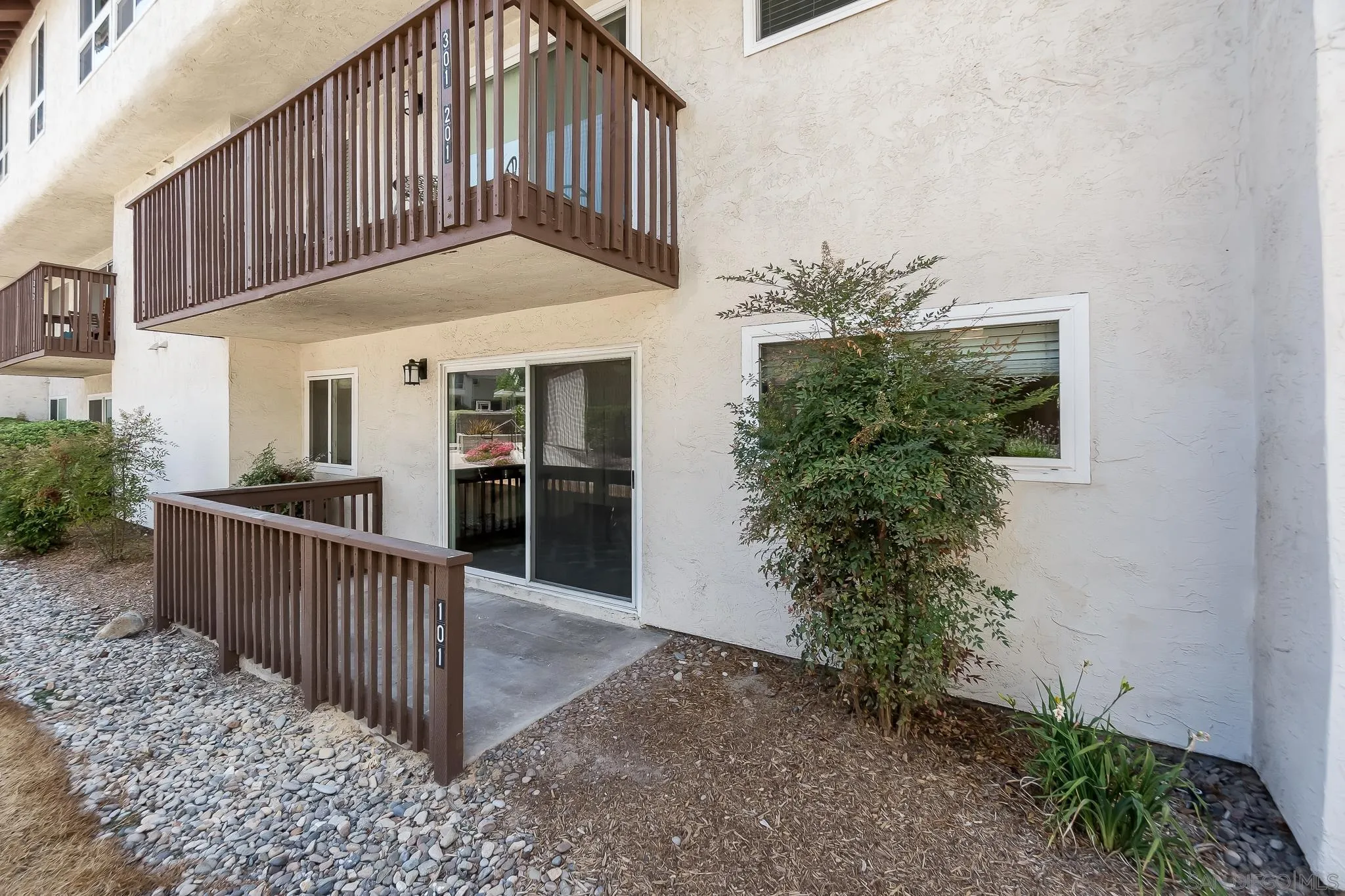 6111 Rancho Mission Road, Unit 101 San Diego, CA 92108 - Photo 19 of 30 a view of a house with plants and wooden fence