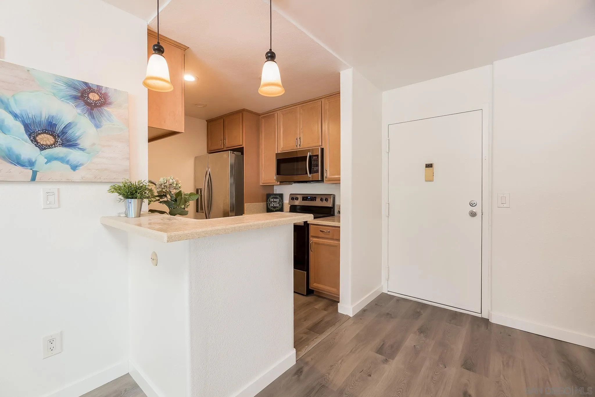 6111 Rancho Mission Road, Unit 101 San Diego, CA 92108 - Photo 6 of 30 a kitchen with stainless steel appliances a refrigerator and a stove top oven