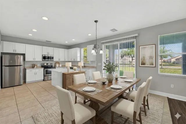 a kitchen with a table chairs microwave and refrigerator
