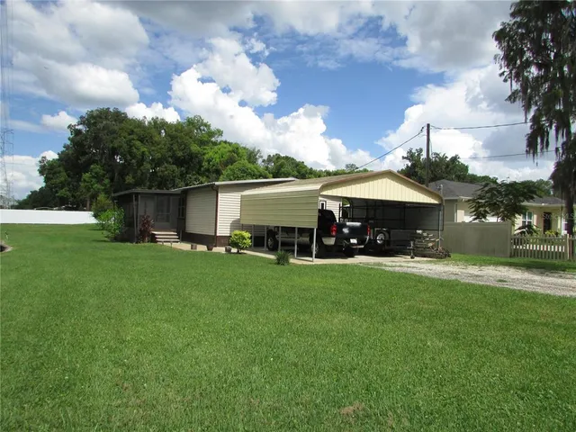 a view of a house with backyard and a tree