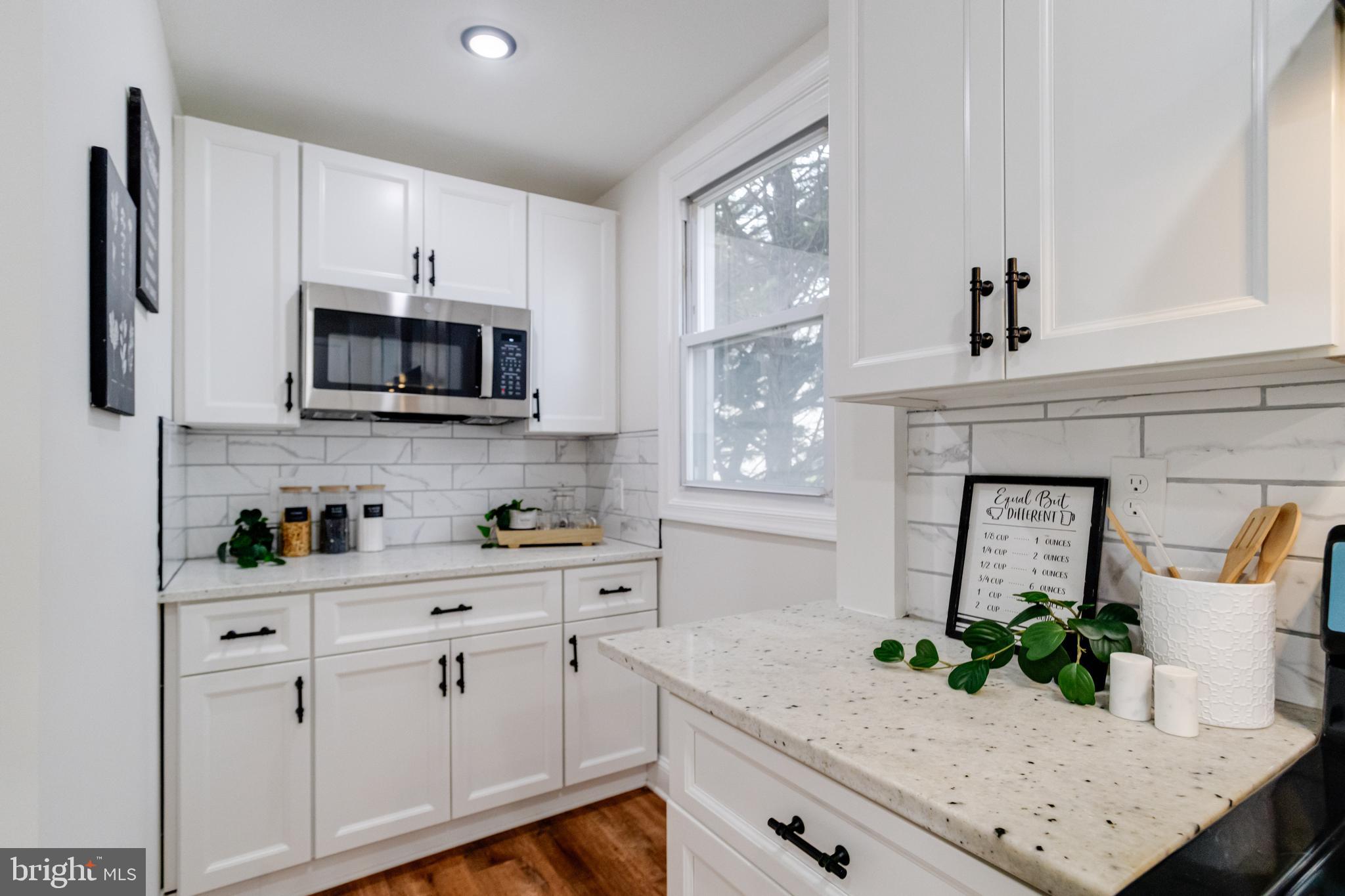 7932 Philadelphia Road Baltimore, MD 21237 - Photo 14 of 44 a kitchen with stainless steel appliances white cabinets a stove a sink and a window
