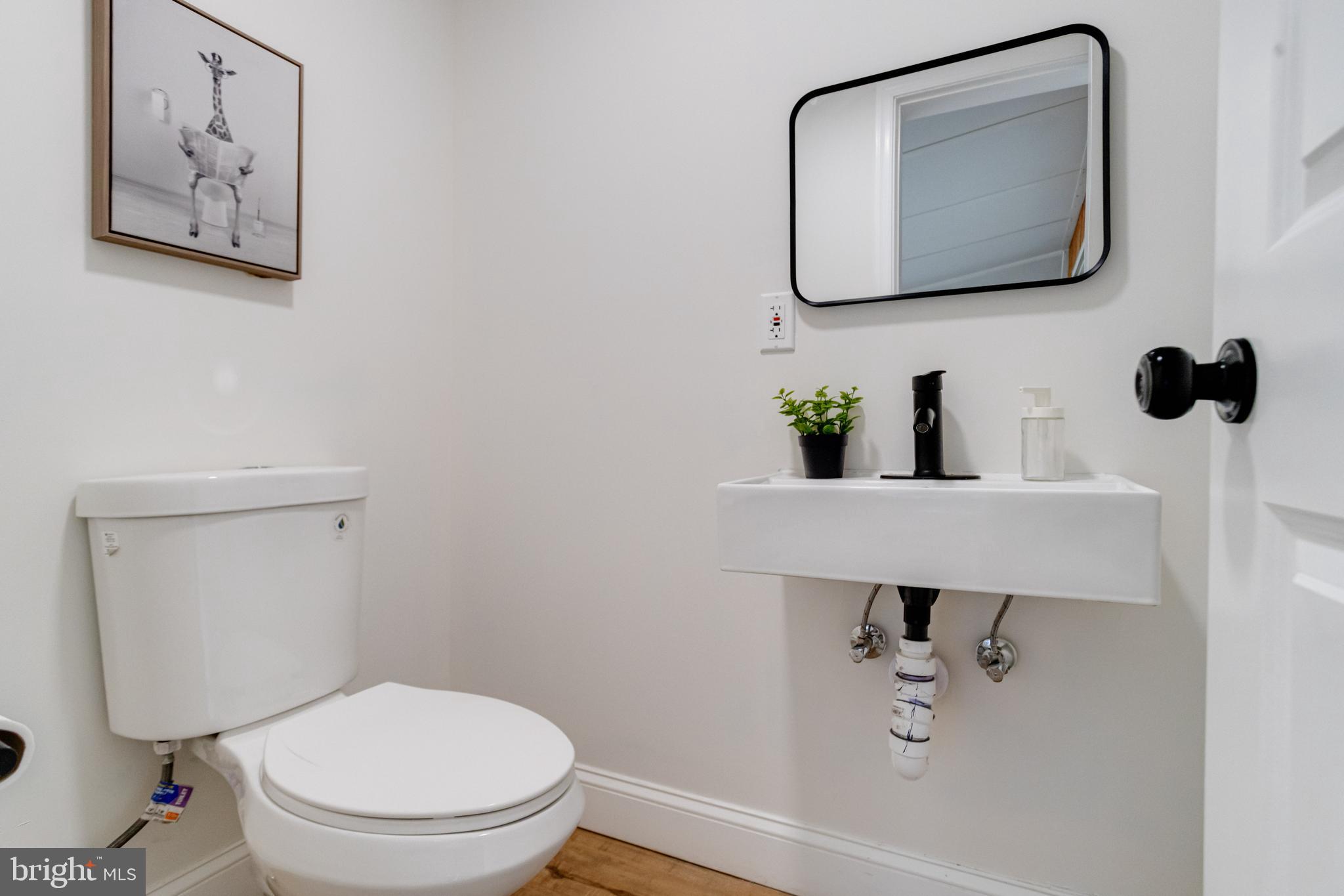 7932 Philadelphia Road Baltimore, MD 21237 - Photo 19 of 44 a bathroom with a toilet sink and mirror