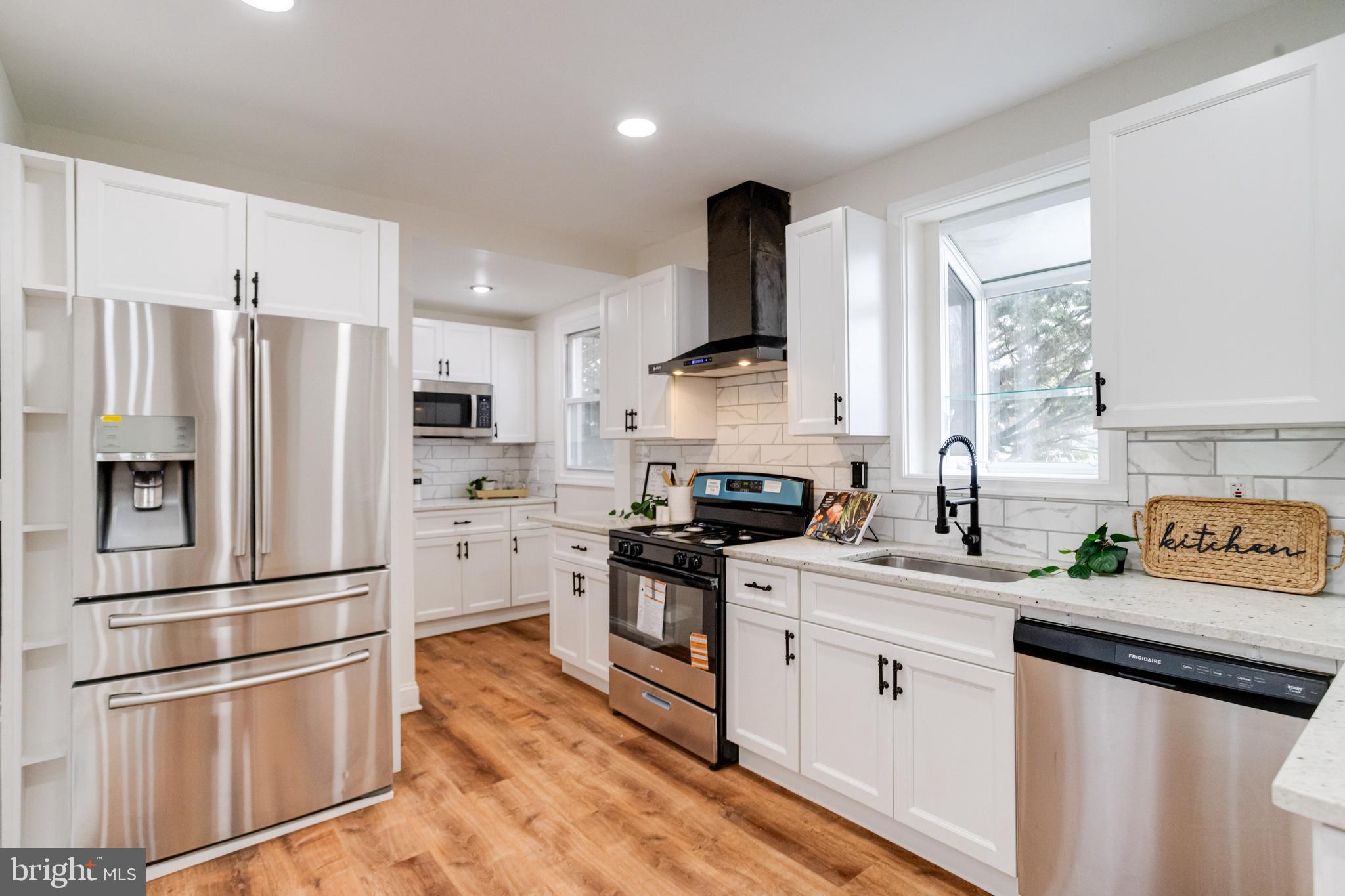 7932 Philadelphia Road Baltimore, MD 21237 - Photo 3 of 44 a kitchen with white cabinets and stainless steel appliances