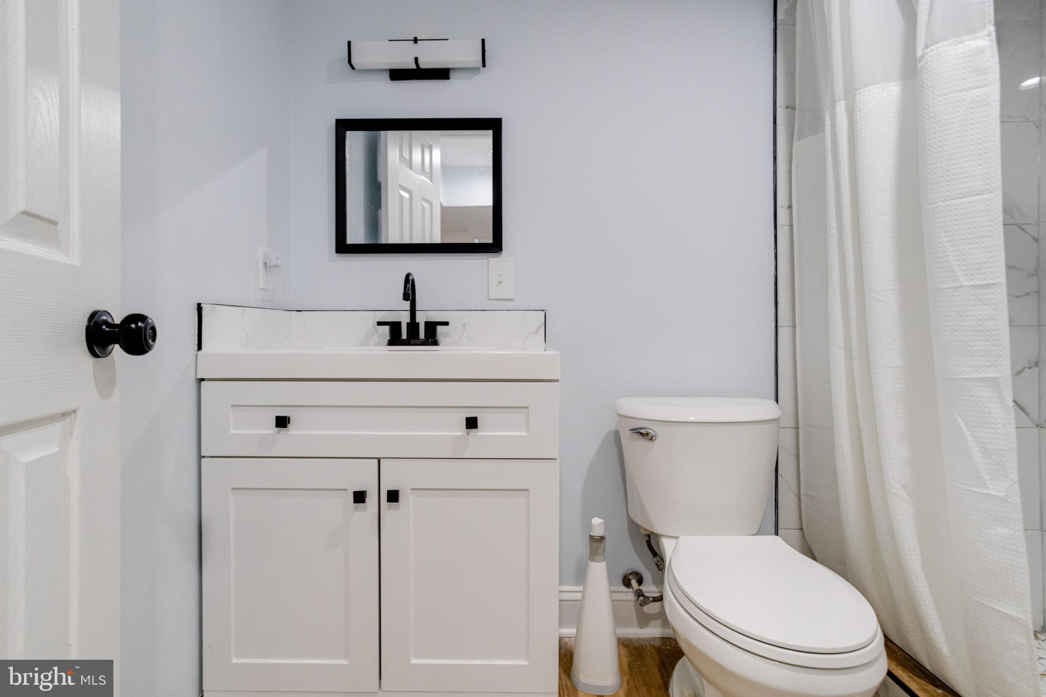 7932 Philadelphia Road Baltimore, MD 21237 - Photo 35 of 44 a bathroom with a toilet sink and mirror
