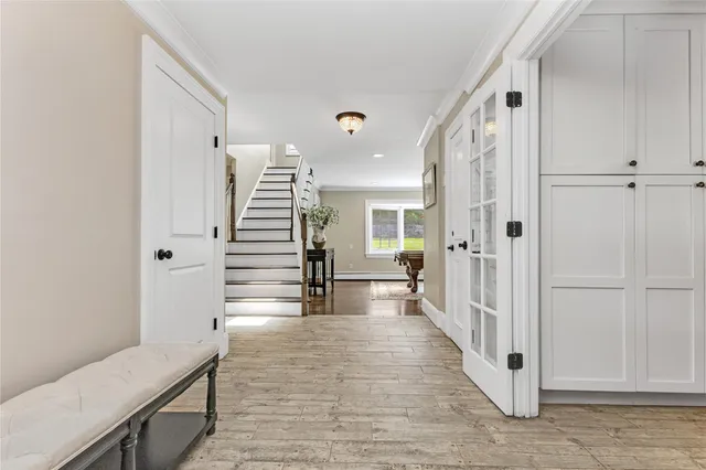 a view of a hallway with wooden floor and staircase