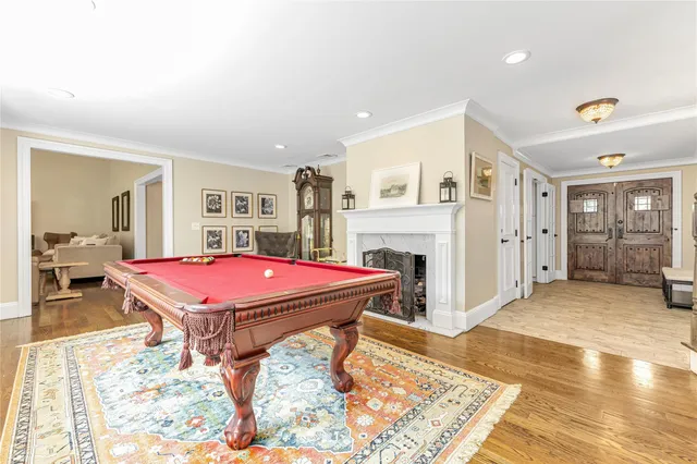 a room with pool table and wooden floor