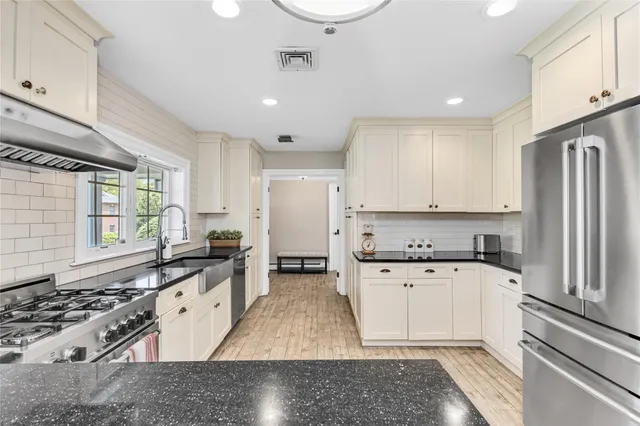 a kitchen with granite countertop a sink stove and refrigerator