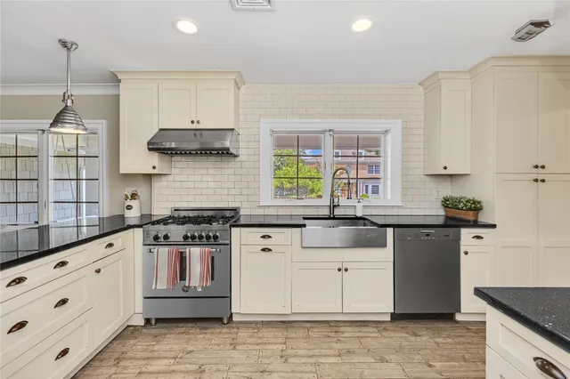 a kitchen with granite countertop a stove sink and cabinets