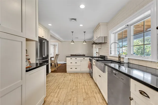 a large white kitchen with stainless steel appliances