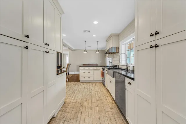 a kitchen with white cabinets and stainless steel appliances