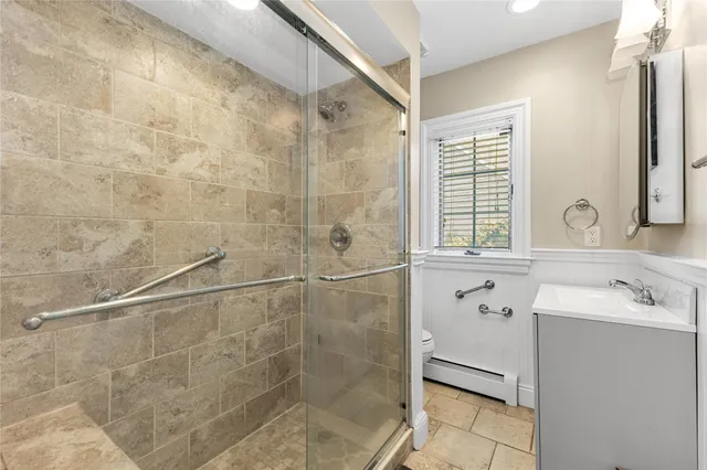 a bathroom with a sink shower and a mirror