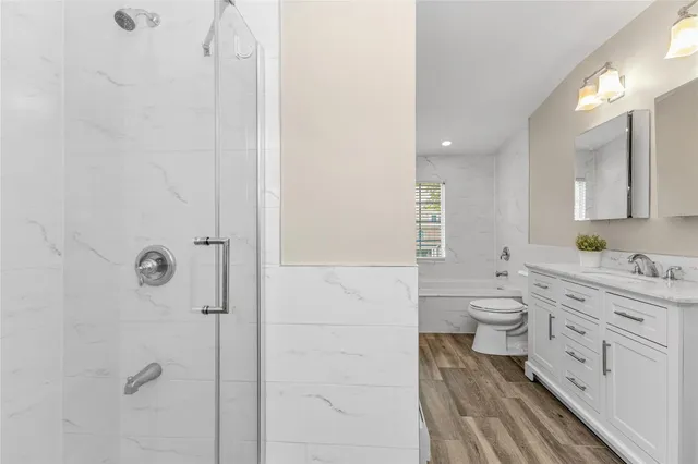 a bathroom with a granite countertop toilet a sink and a mirror