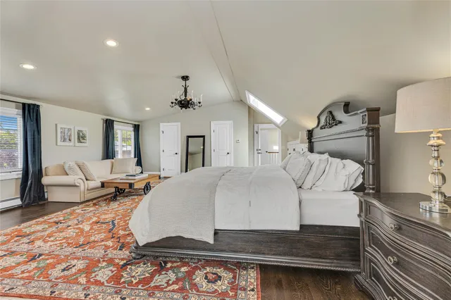 a large bedroom with a bed and wooden floor