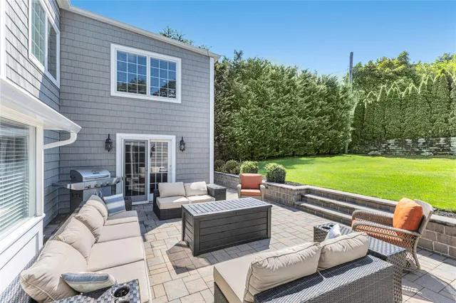 a view of a patio with couches chairs potted plants and a big yard