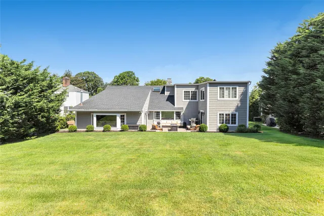a view of a big house with a big yard and large trees