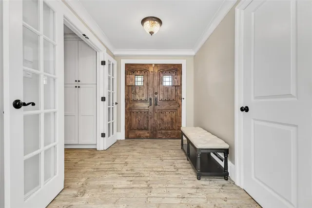 a view of a hallway with wooden floor and a bathroom