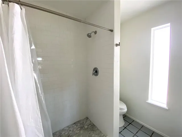 a bathroom with a toilet and a shower