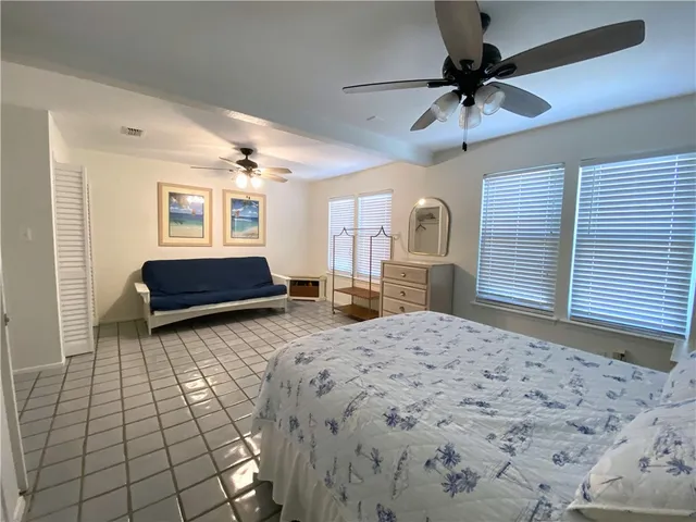 a spacious bedroom with a bed and a dresser