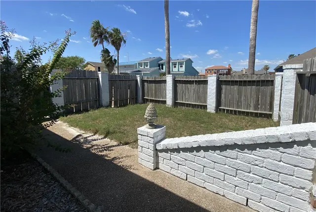 a view of a backyard with wooden fence