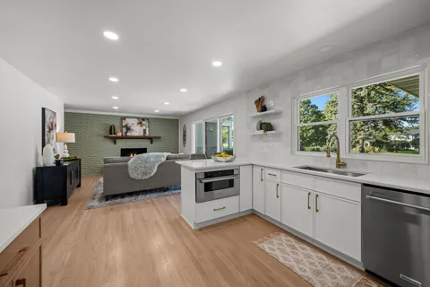 a large white kitchen with sink stove and cabinets