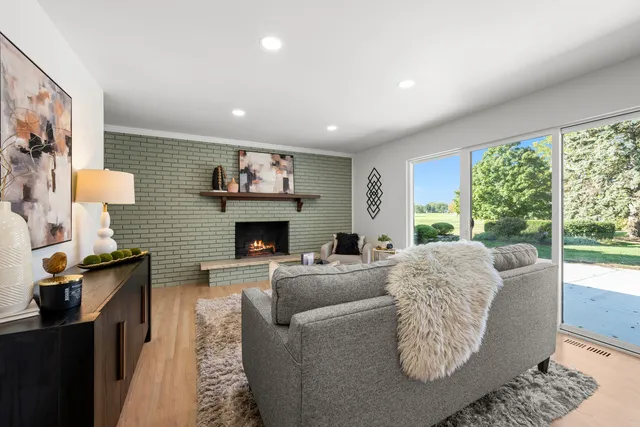 a living room with furniture a large window and a fireplace