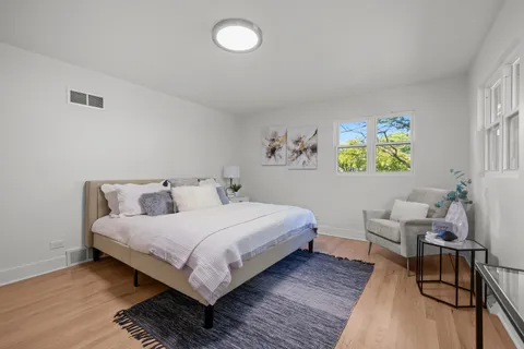 a bedroom with a bed and painting on the wall