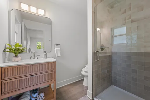 a bathroom with a sink a toilet and shower