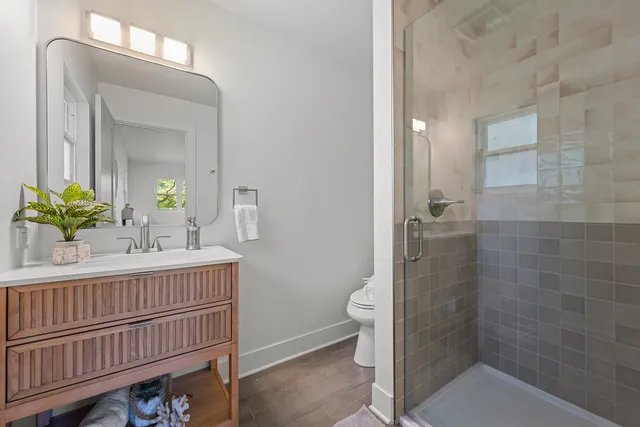 a bathroom with a sink a toilet and shower