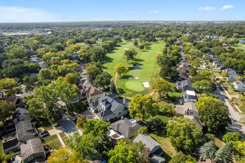 an aerial view of residential houses with outdoor space and trees