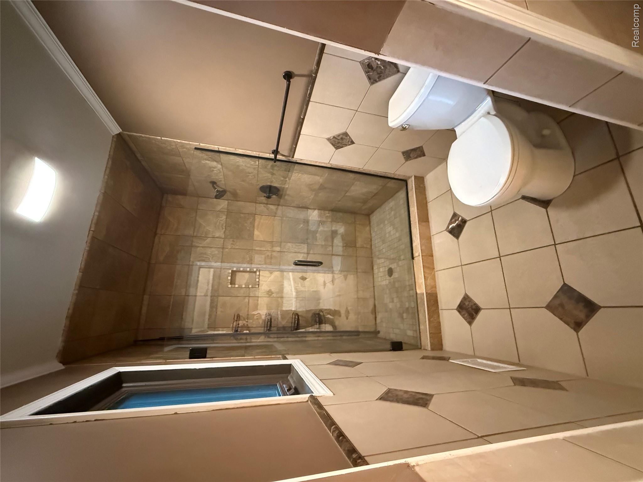 10280 Nimphie Road Fenton, MI 48430 - Photo 15 of 30 Tiled walk-in shower with a glass enclosure, a built-in shower niche, and dark-toned fixtures