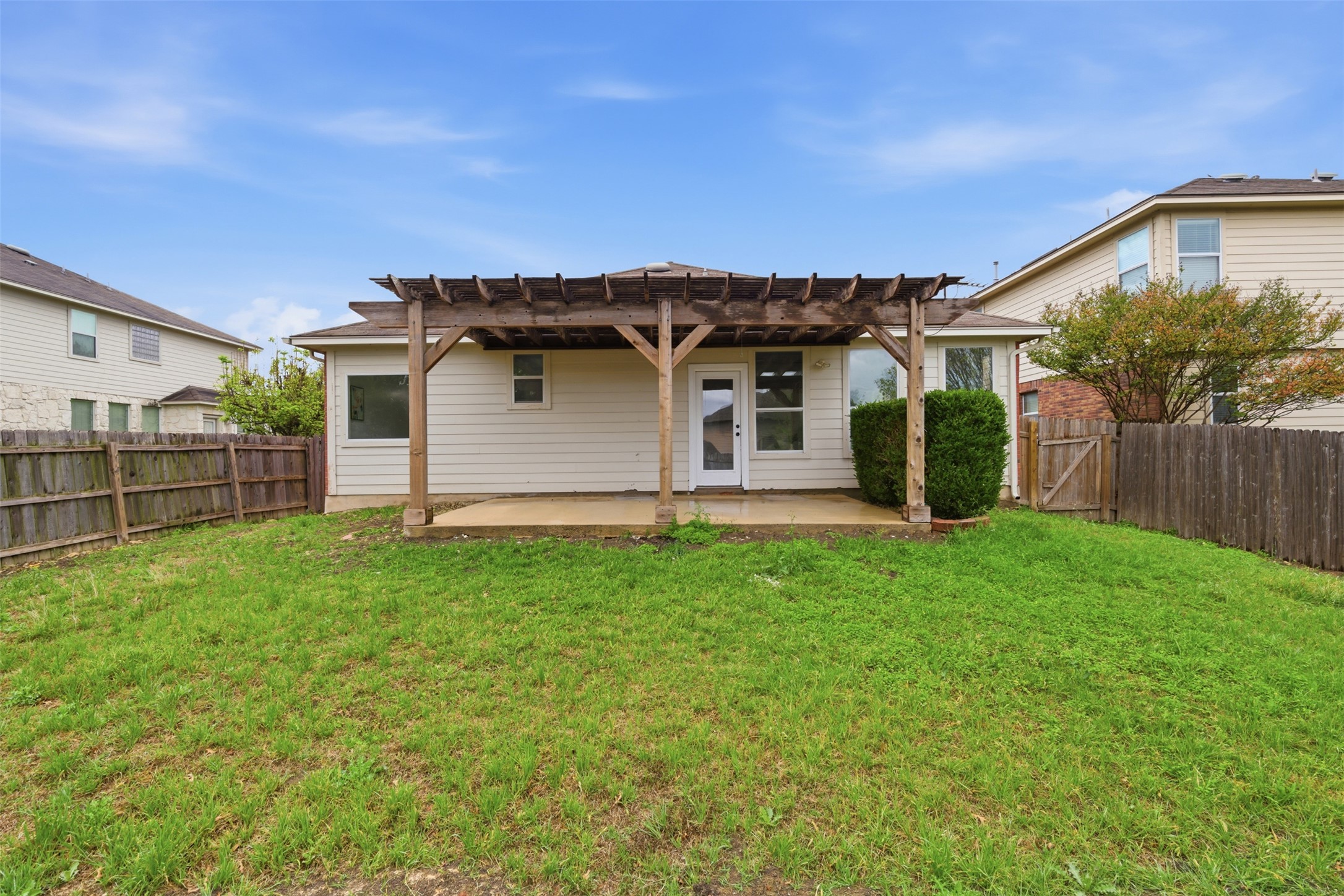 461 Hot Spring Valley Buda, TX 78610 - Photo 23 of 25 The property features a spacious yard with a lawn, a wooden pergola, and a concrete patio