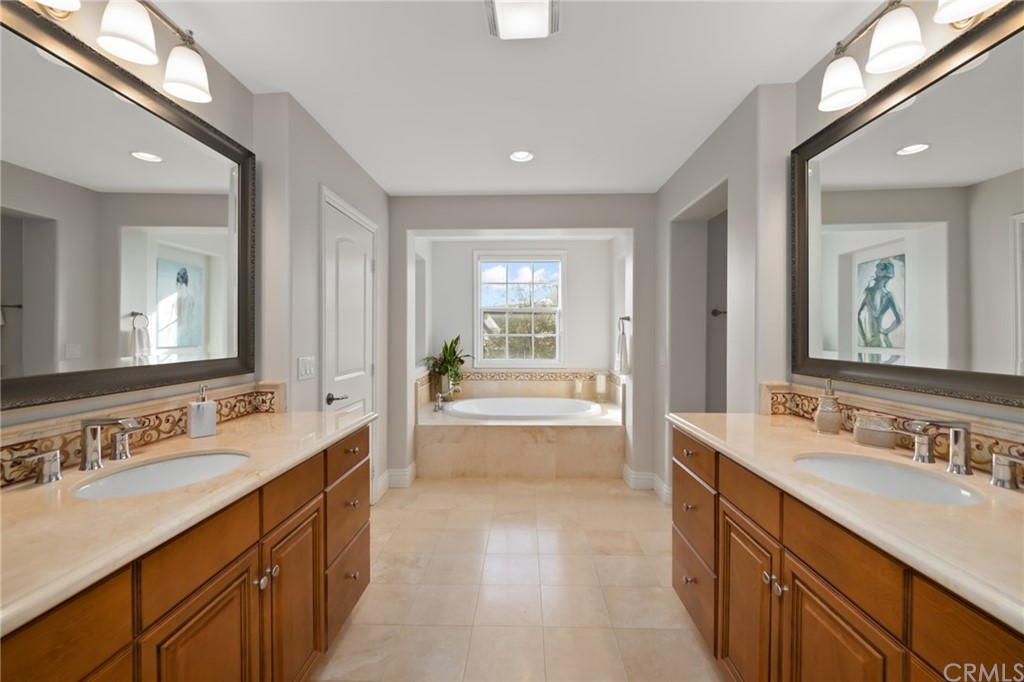 825 Cambridge Court Pasadena, CA 91107 - Photo 45 of 58 a spacious bathroom with a double vanity sink a large mirror and a bathtub