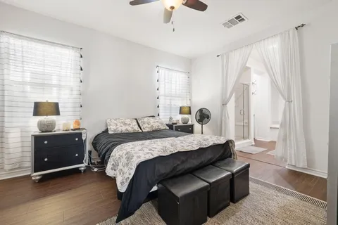 a bedroom with a bed and a flat tv screen on dresser