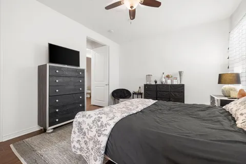 a bedroom with a bed and dresser with mirror