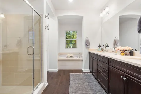 a bathroom with a tub shower and a mirror