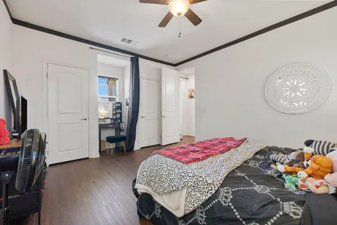 a spacious bedroom with a bed and a flat screen tv