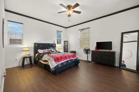 an empty room with wooden floor cabinet and windows