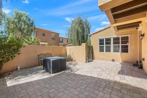 a backyard of a house with large trees and barbeque oven