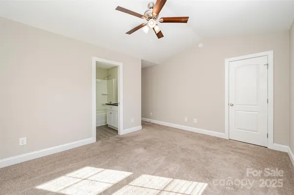 an empty room with fan and windows