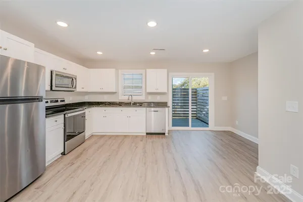 a kitchen with stainless steel appliances a refrigerator sink and cabinets