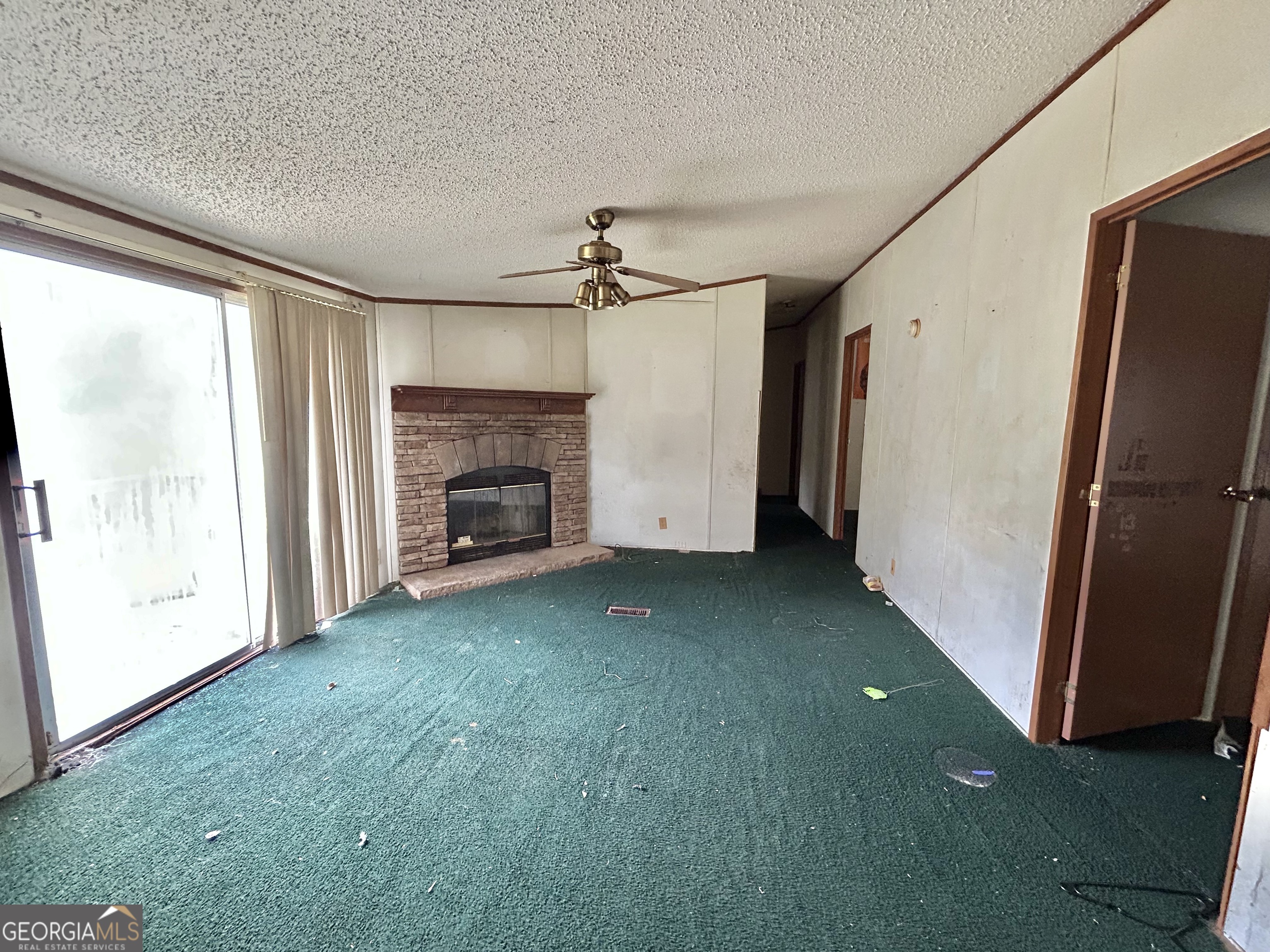 1299 Bodie Rayle Road Elberton, GA 30635 - Photo 5 of 18 a view of an empty room with a fireplace and a window