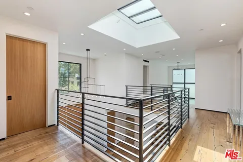 a view of a hallway with wooden floor and cabinet