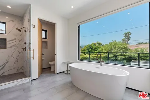 a bathroom with a sink shower and a mirror