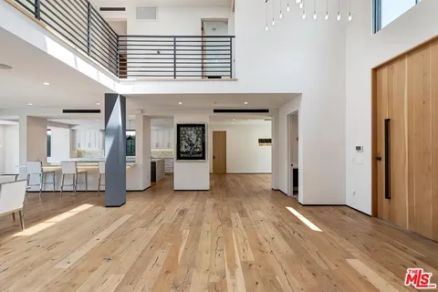 an entryway of a room with wooden floor and windows