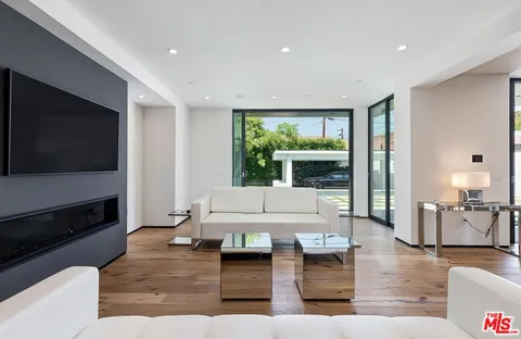 a dining room with wooden floor and a floor to ceiling window