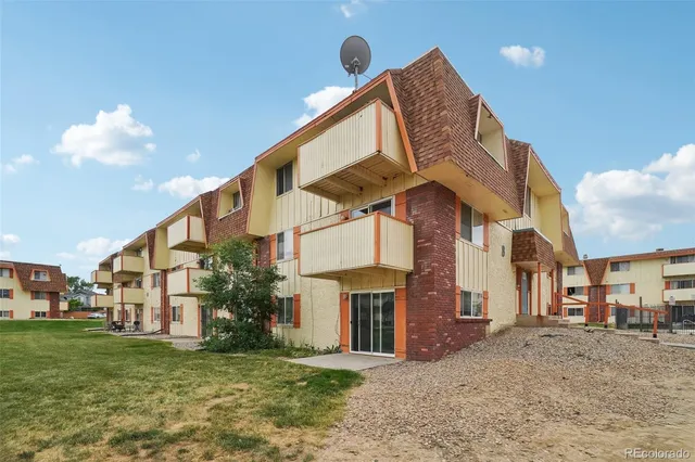 a view of a house with a yard and pathway