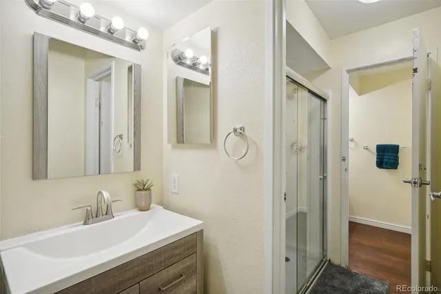 a bathroom with a sink vanity granite shower and a mirror